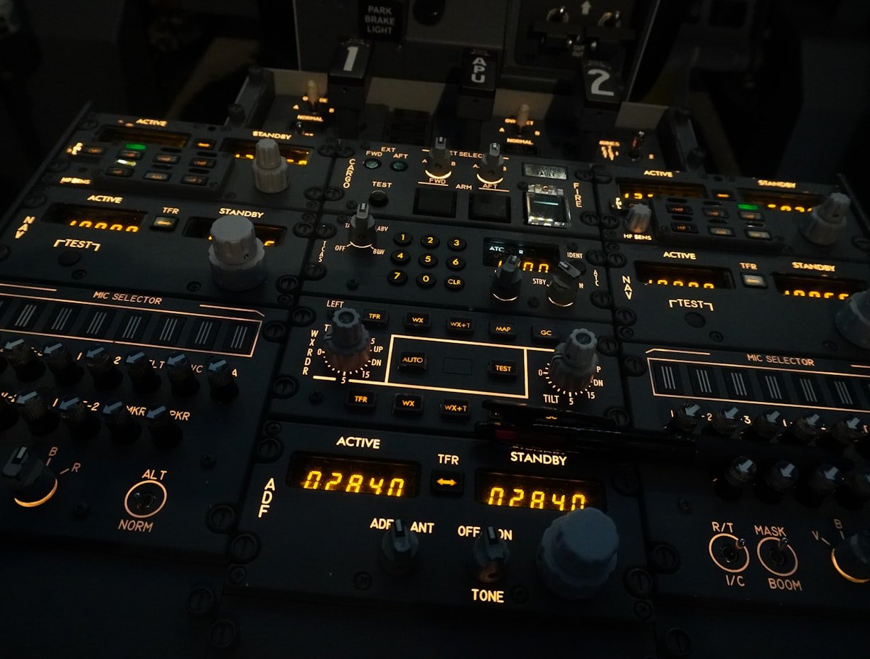 A complex aircraft cockpit control panel with dials, switches and illuminated displays labelled ACTIVE, STANDBY and MIC SELECTOR.